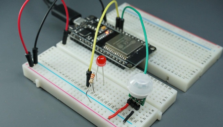 ESP32 на макетной плате, подключённый к светодиоду и PIR-датчику движения